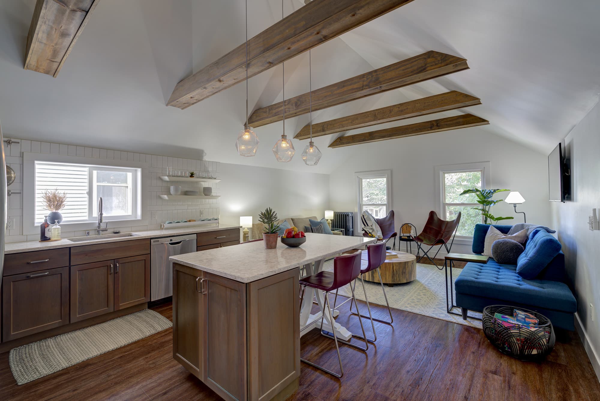 Open-plan kitchen and living room with vaulted ceiling and wood beams