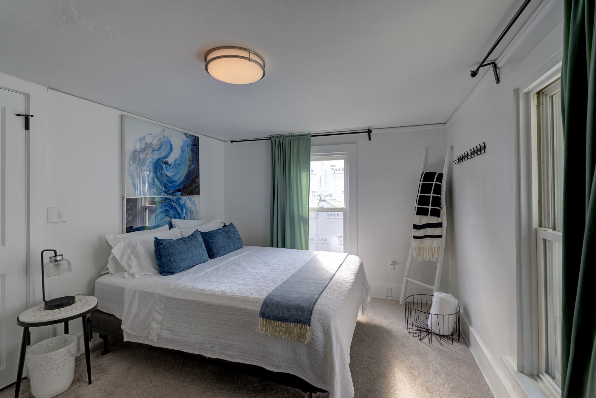 Second bedroom with queen bed and blue accent art